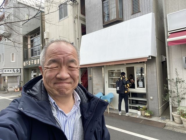 みかづきベーカリーの店頭をバックに自撮りする鈴木義晴（2021.3.5）スプラッシュ