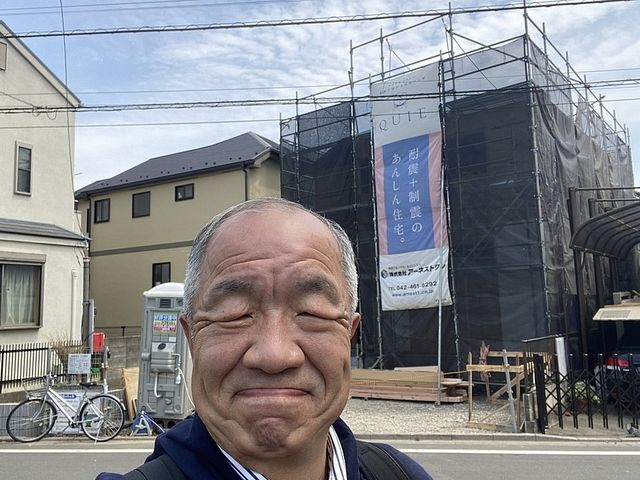 西東京市下保谷3丁目の新築一戸建ての現場をバックに自撮りする鈴木義晴（2021.4.25）スプラッシュ
