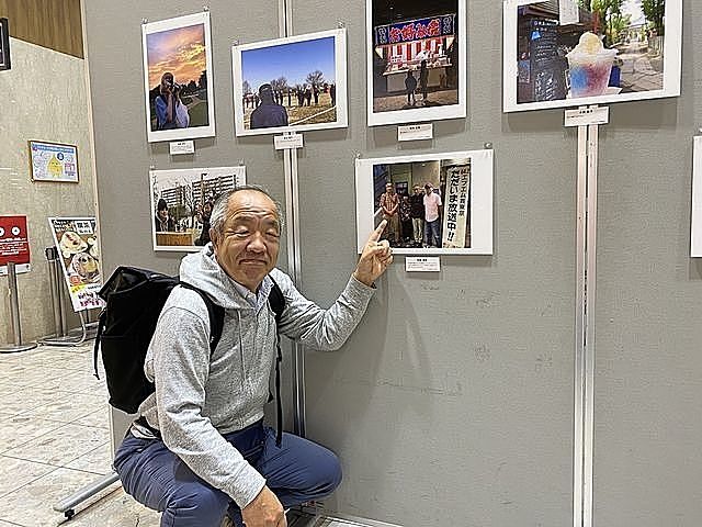 第二回西東京百姿に展示されて写真を背景にする「おとなの喫茶店」マスターの鈴木義晴
