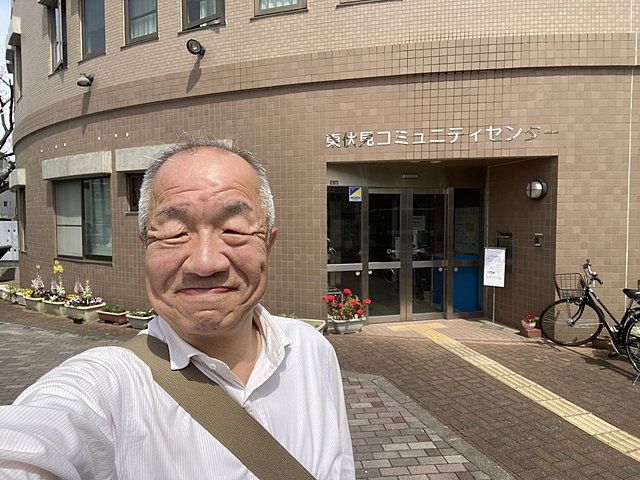 東伏見コミュニティセンターを背景に自撮りする鈴木義晴・スプラッシュ